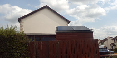 Solar panels on shed with house in background